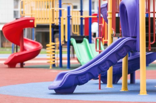 a colorful children's playground with the focus on a purple slide