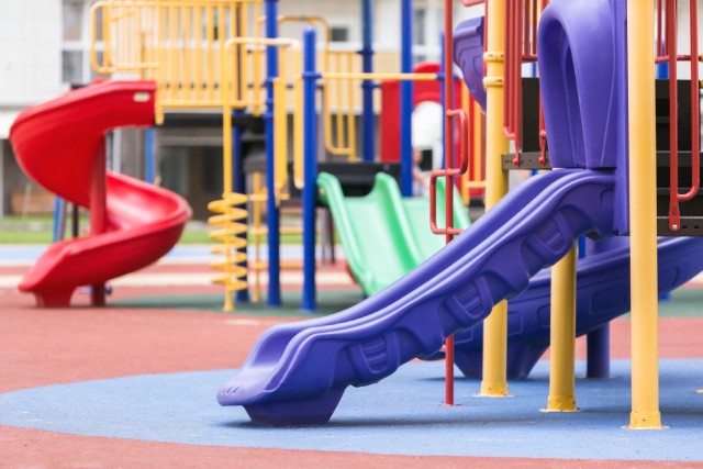 a colorful children's playground with the focus on a purple slide