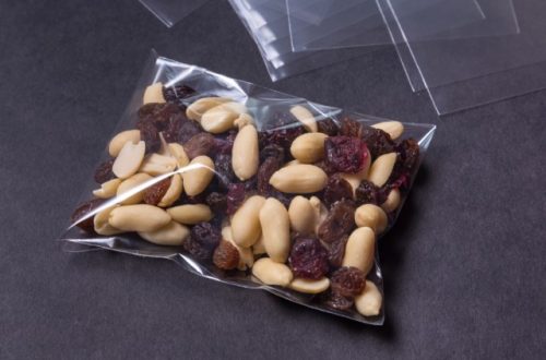 An assortment of nuts and raisins are wrapped in clear packaging to make them convenient to pack and carry around.