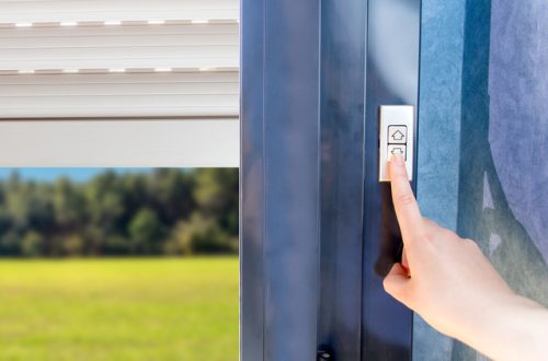 A close-up view shows a person using their finger to press the down arrow to control their electric shutters.