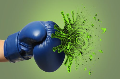 A blue boxing glove punches an exploding green germ, symbolizing germ prevention through a strong defense against bacteria.